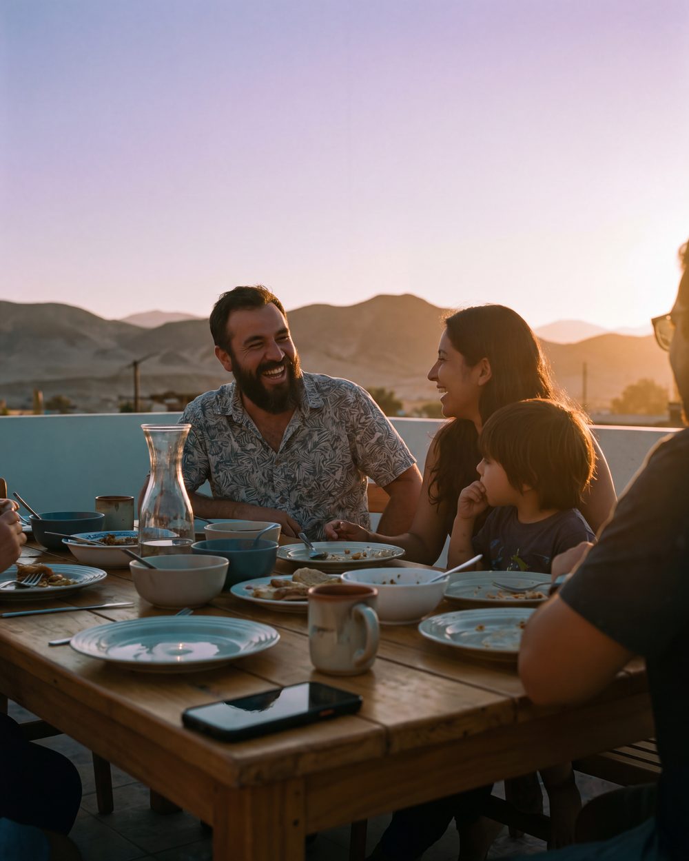 Dueño de una pyme cena con su familia en una terraza al atardecer en Copiapó, con el celular boca abajo sobre la mesa